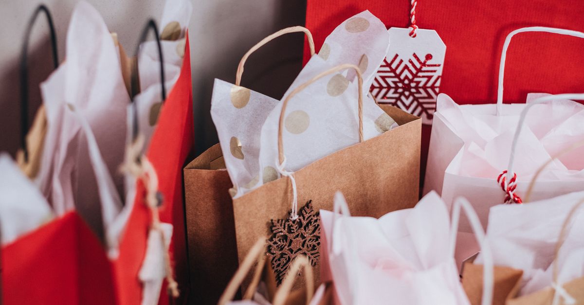 Collection of festive shopping bags filled with holiday gifts.